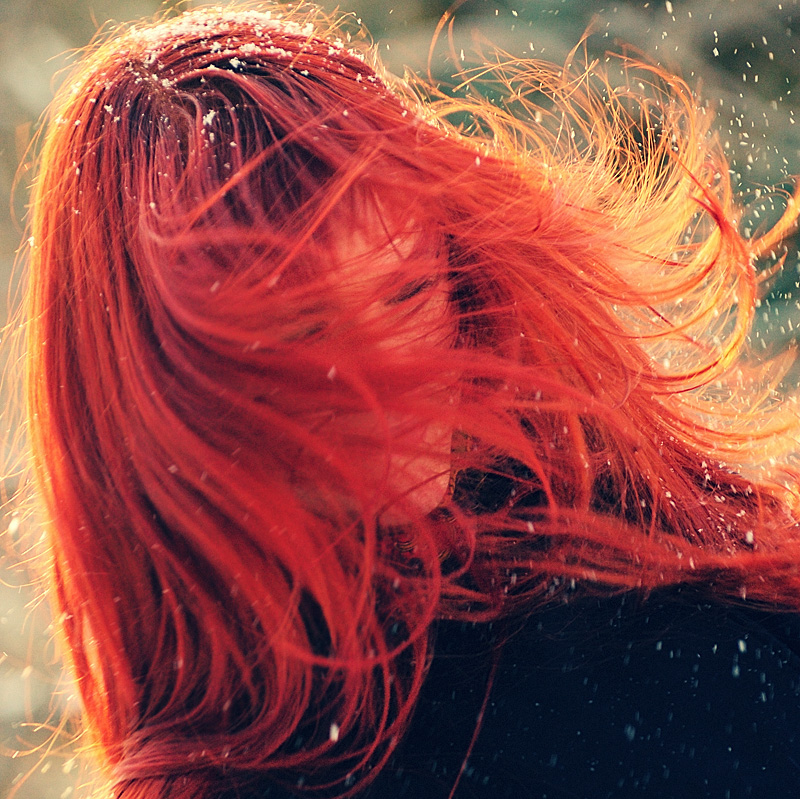 Фото Ветер развивает рыжие волосы девушки.