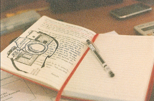 caderno, caneta and canon